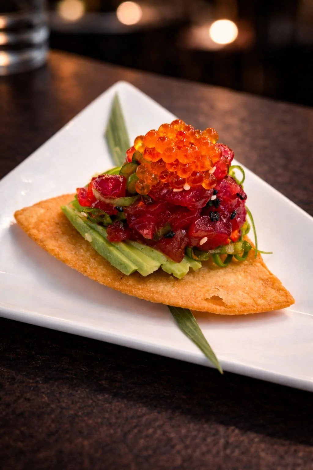 Diced raw tuna and avocado on a crispy base, topped with orange roe